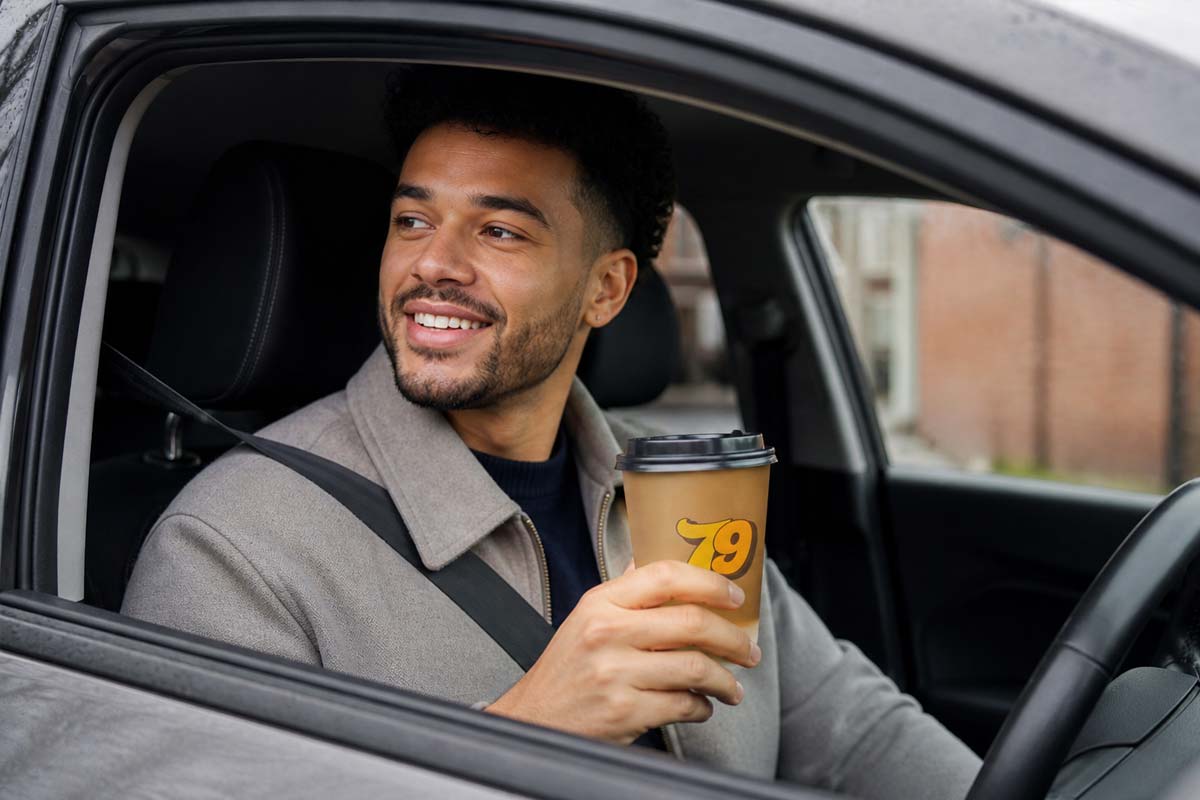 Man driving with coffee on the go